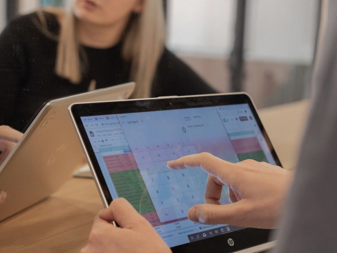 A science apprentice uses a touch screen laptop to put numbers in a spreadsheet.